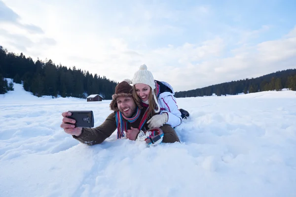 Romantikus pár a friss hó, és figyelembe selfie — Stock Fotó