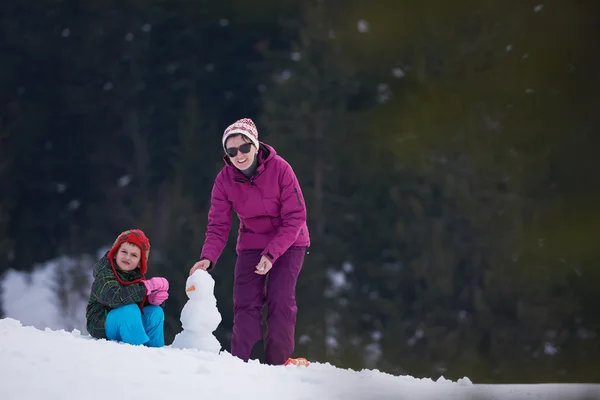 Mãe e filho construindo boneco de neve — Fotografia de Stock