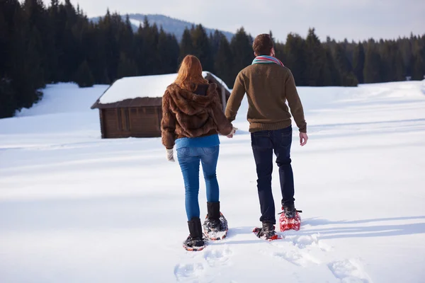 Casal se divertindo em sapatos de neve — Fotografia de Stock