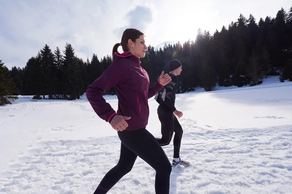 Couple jogging outside on snow — Stock Photo, Image