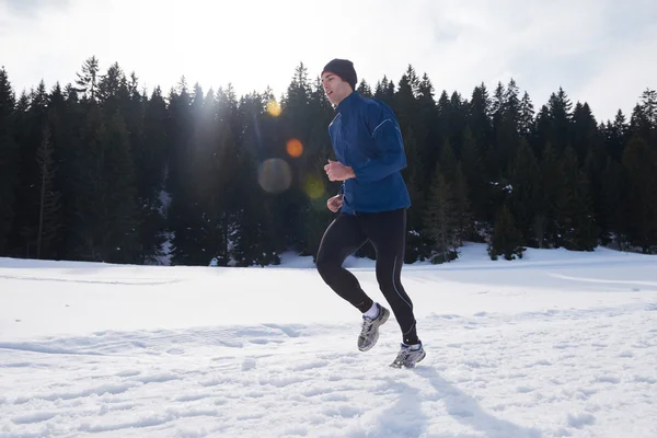 Homme jogging sur la neige dans la forêt — Photo