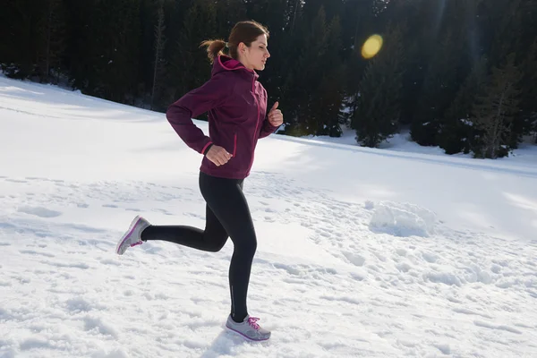 Fiatal nő a havat az erdőben kültéri jogging — Stock Fotó