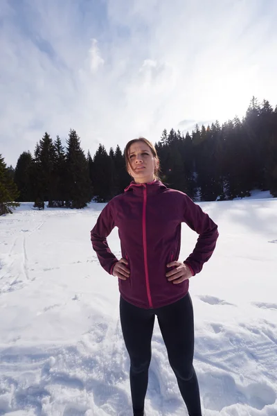 Jonge vrouw joggen buiten op sneeuw in bos — Stockfoto