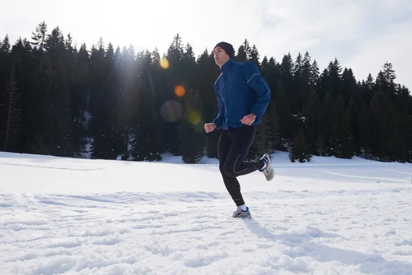 Людина біжить на снігу в лісі — стокове фото