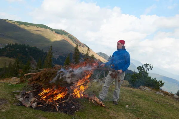 Pěší turistika muže zkusit světlo ohně — Stock fotografie