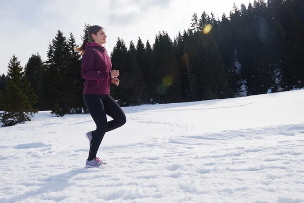 Fiatal nő a havat az erdőben kültéri jogging — Stock Fotó