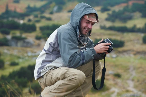 Hiking man prepare tasty sausages on campfire Stock Photo