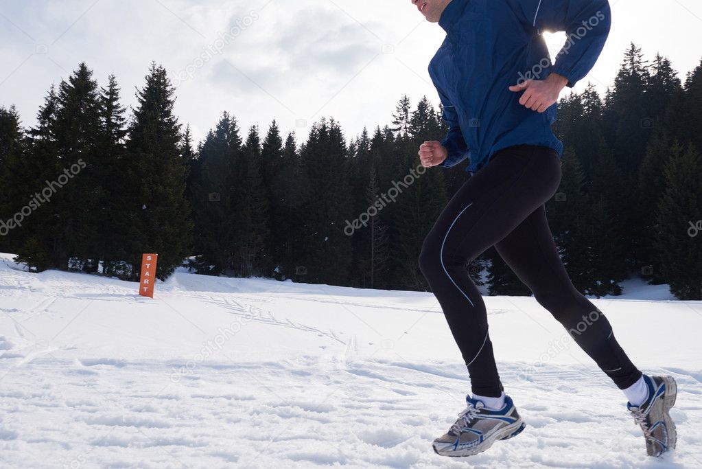 man jogging on snow in forest