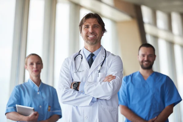 Group of medical staff at hospital, handsome doctor in front — Stock Photo, Image