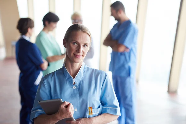 Medico donna con tablet in piedi davanti al team — Foto Stock