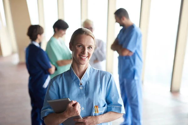 Medico donna con tablet in piedi davanti al team — Foto Stock