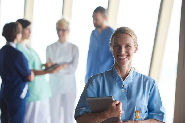 Medico donna con tablet in piedi davanti al team — Foto Stock