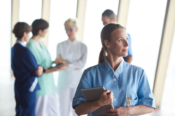 Medico donna con tablet in piedi davanti al team — Foto Stock