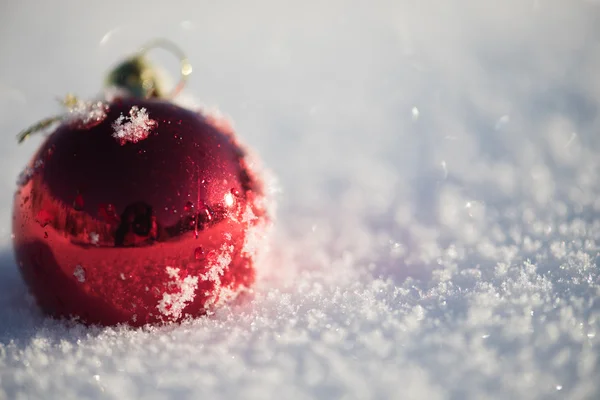 美しい晴れた冬の日に新鮮な雪の背景でクリスマスの赤いボールの装飾 — ストック写真