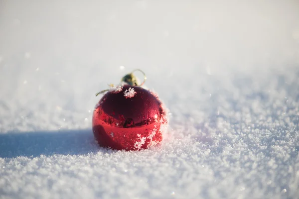 美しい晴れた冬の日に新鮮な雪の背景でクリスマスの赤いボールの装飾 — ストック写真