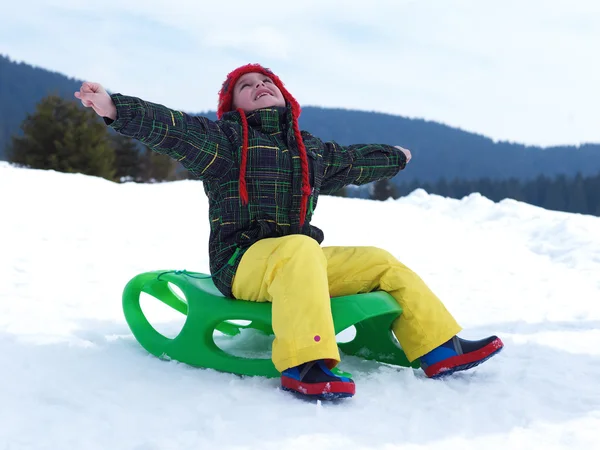 Мальчик веселится на зимних каникулах на свежем снегу — стоковое фото