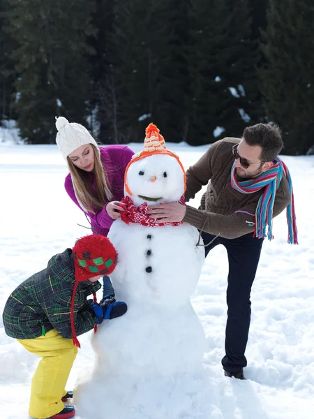 Familia feliz haciendo muñeco de nieve —  Fotos de Stock