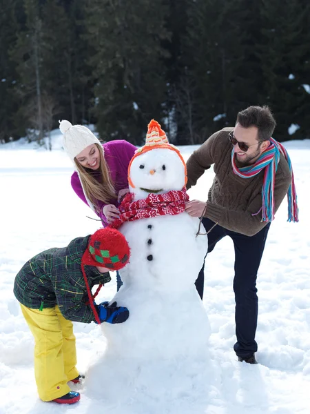 Familia feliz haciendo muñeco de nieve —  Fotos de Stock