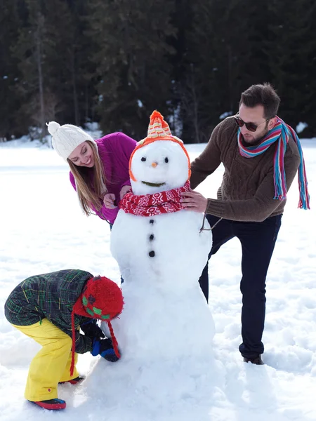 Familia feliz haciendo muñeco de nieve —  Fotos de Stock