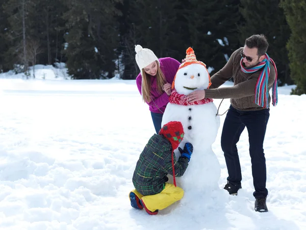 Felice famiglia facendo pupazzo di neve — Foto Stock