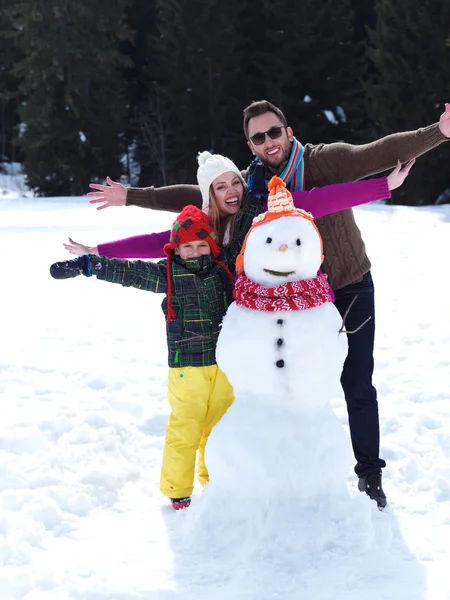 Gelukkige familie sneeuwpop maken — Stockfoto