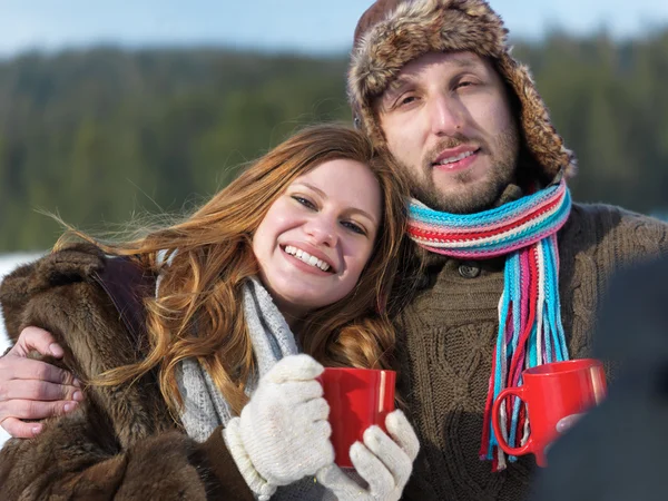 快乐的年轻夫妇，在冬天喝热茶 — 图库照片