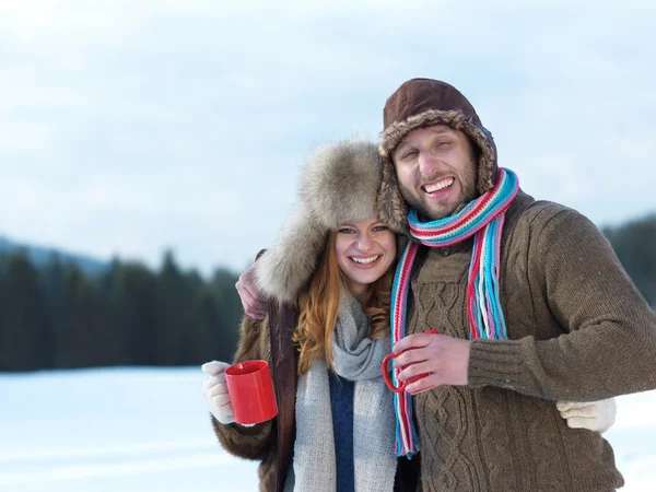 Heureux jeune couple boire du thé chaud en hiver — Photo