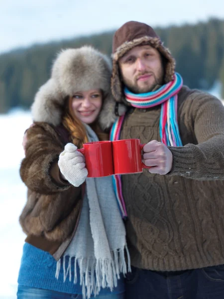 Счастливая молодая пара пьет теплый чай зимой — стоковое фото