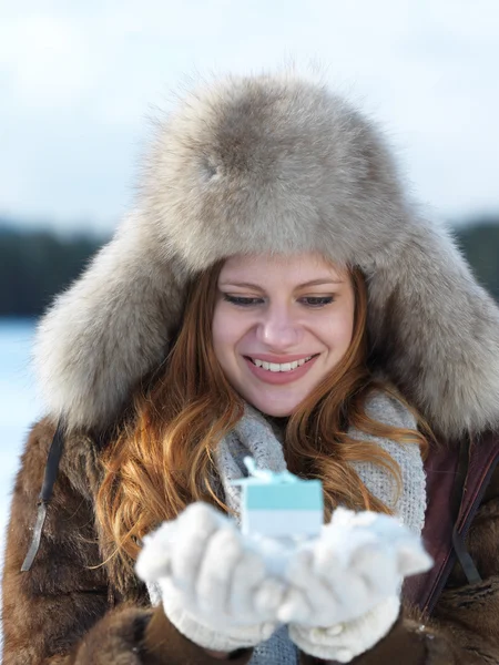 Meisje met gift bij winters tafereel — Stockfoto