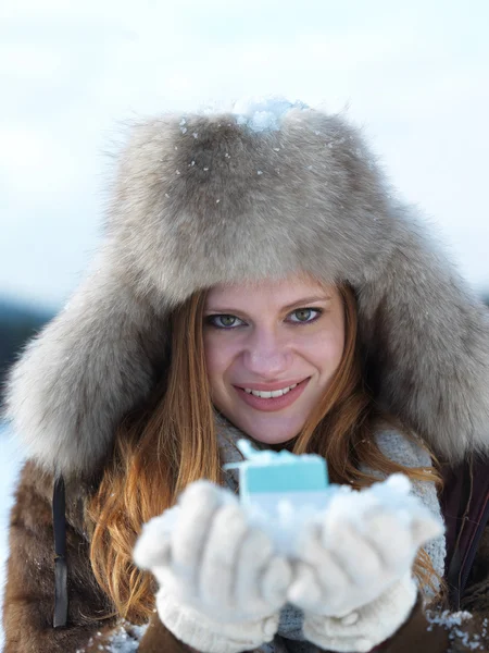 Meisje met gift bij winters tafereel — Stockfoto