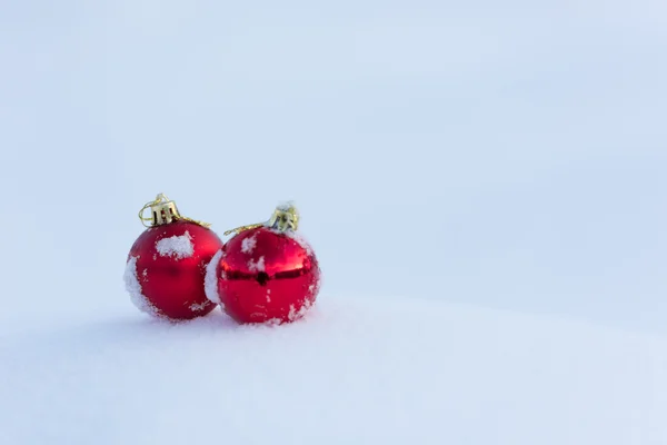 新鮮な雪の中の赤いクリスマス ボール — ストック写真