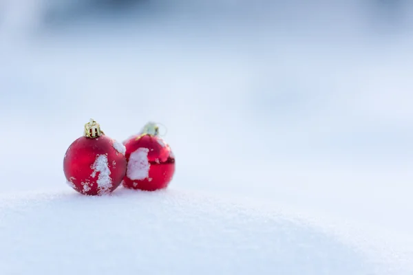 新鮮な雪の中の赤いクリスマス ボール — ストック写真