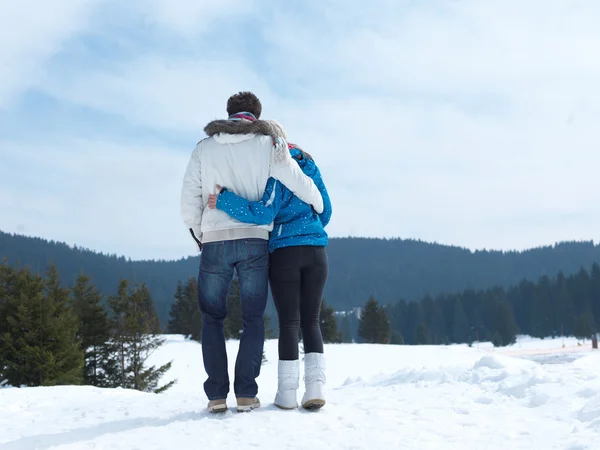 Casal se divertindo na neve fresca em férias de inverno — Fotografia de Stock