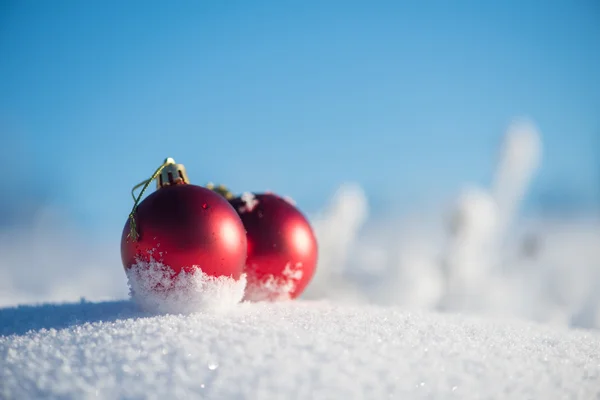 新鮮な雪の中の赤いクリスマス ボール — ストック写真