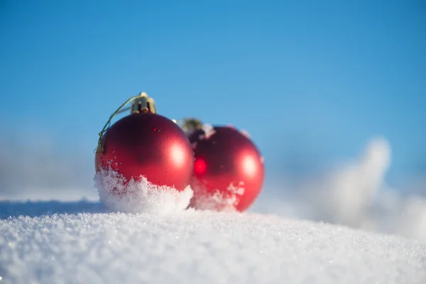 新鮮な雪の中の赤いクリスマス ボール — ストック写真