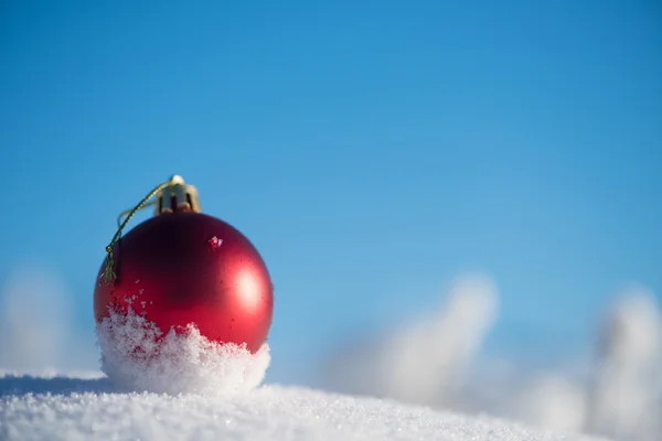 新鮮な雪の中の赤いクリスマス ボール — ストック写真