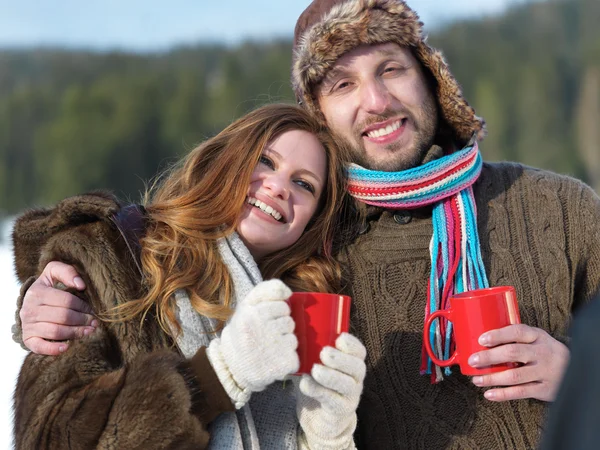 Feliz joven pareja bebiendo té caliente en invierno —  Fotos de Stock