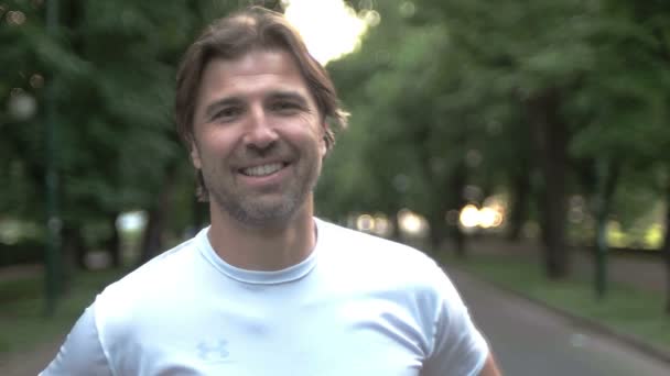 Portrait d'un sportif souriant dans le parc — Video