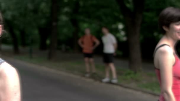 Groep vrienden doen pauze na joggen in het park — Stockvideo