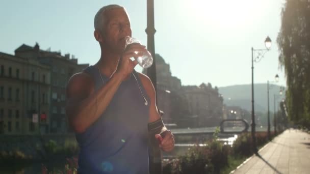 Senior joggen man vers drinkwater — Stockvideo