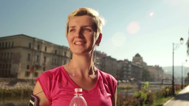 Jonge vrouw drinken een water na het joggen — Stockvideo