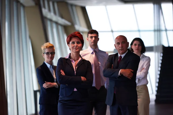 Группа бизнесменов с рыжеволосой женщиной впереди — стоковое фото