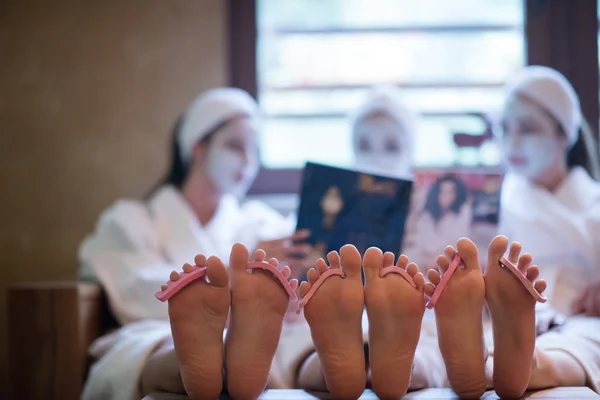 Vrijgezellenfeest in spa, meisjes met gezichtsmasker lezen tijdschrift — Stockfoto