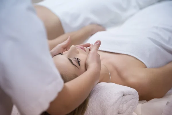 Жінка отримує масаж обличчя і голови в спа-салоні — стокове фото