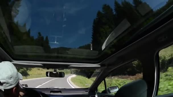 Чоловік керує автомобілем на заміській дорозі — стокове відео
