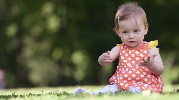 Счастливый новорожденный ребенок играет с травой — стоковое видео