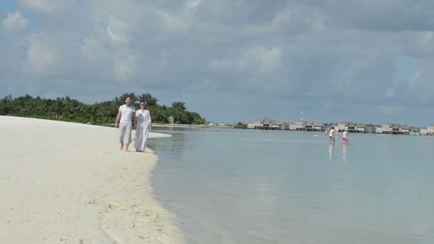 Par att ha kul tillsammans som promenerar på stranden — Stockvideo