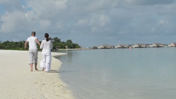 Paar hat Spaß beim gemeinsamen Spazierengehen am Strand — Stockvideo