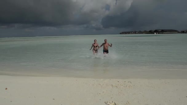 Man en vrouw, jongeren op tropische wit zand strand — Stockvideo