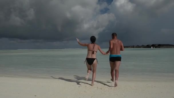 Man en vrouw, jongeren op tropische wit zand strand — Stockvideo